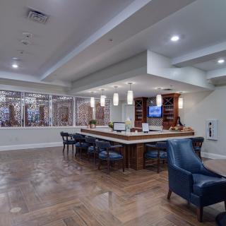 A modern lounge area featuring comfortable seating, wooden flooring, and a well-lit interior.