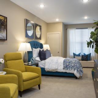A modern bedroom featuring vibrant yellow chairs and a stylishly designed bed.
