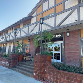 A tudor-style building with brick accents and an entrance featuring outdoor seating.