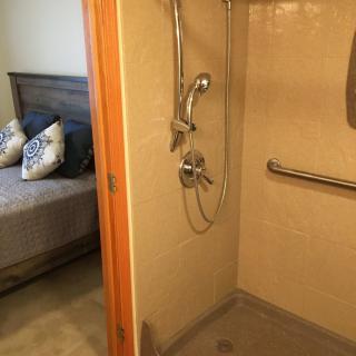 An accessible shower adjacent to a bedroom.