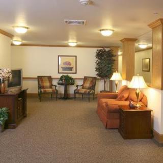 A cozy living room with comfortable seating, a TV, and warm lighting.