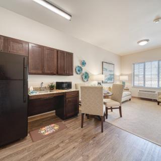 A modern apartment with an open kitchen, dining area, and living room.
