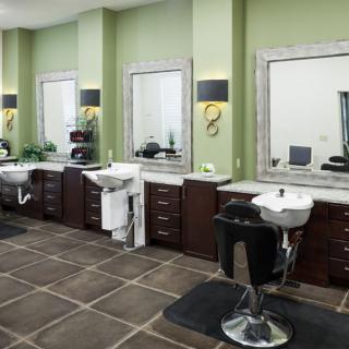 A modern barbershop interior with chairs, mirrors, and sinks.