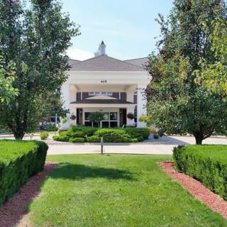 A well-maintained building entrance surrounded by lush greenery and manicured landscaping.