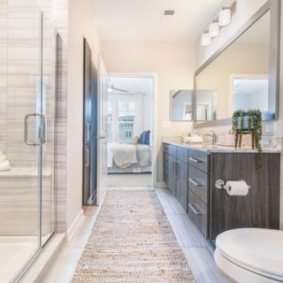 A modern and spacious bathroom with a glass shower, sleek vanity, and large mirror.