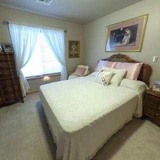 A cozy bedroom with a neatly made bed and soft lighting.