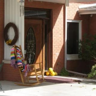 A welcoming front porch with a rocking chair and decorative wreath.