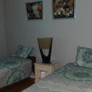 A cozy bedroom with twin beds, a nightstand, and decorative artwork on the wall.