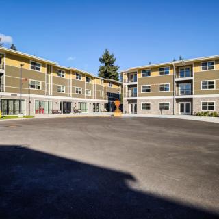 A modern apartment complex with multiple units and a large parking area.