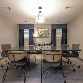 A modern conference room featuring a large table, comfortable chairs, and contemporary decor.