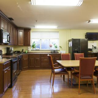 A spacious kitchen with wooden cabinets and a dining area featuring a table and chairs.