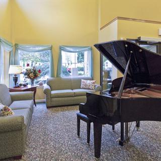 A cozy living room featuring a grand piano and comfortable seating.