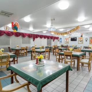 An interior view of an empty restaurant dining area with neatly arranged tables and chairs, adorned with decorative elements.