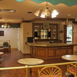 An empty cafe interior featuring a bar counter and wooden furniture.