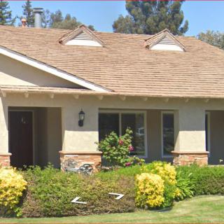 A suburban house with a well-maintained garden and landscaping.
