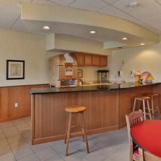 A cozy kitchen area with a wooden counter and bar stool seating.