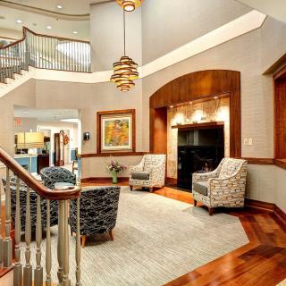 A beautifully designed living room with elegant furnishings and a sweeping staircase.