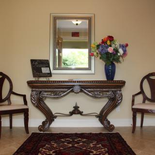 Elegant hallway with a decorative console table, mirror, and floral arrangement.