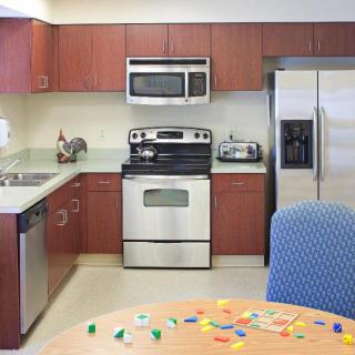 A modern kitchen with stainless steel appliances and wooden cabinets.