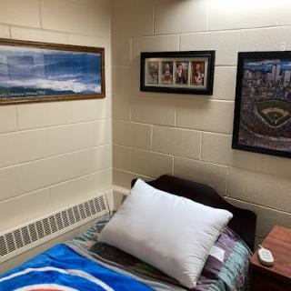 A cozy dorm room featuring sports memorabilia and framed artwork.