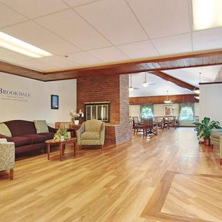 A spacious and well-lit lobby area featuring comfortable seating and wooden floors.