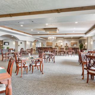 Spacious dining area with elegant wooden furniture and soft lighting.