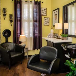 A cozy hair salon interior with comfortable chairs and stylish decor.