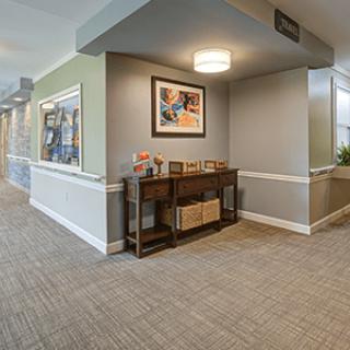 A well-lit, modern hallway with a console table and artwork on the wall.