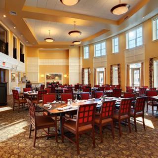 Elegant dining area with tables and chairs arranged in a spacious restaurant setting.
