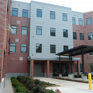 A modern residential building with brick and metal facade.