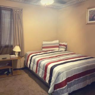 A cozy bedroom with striped bedding and a warm ambiance.