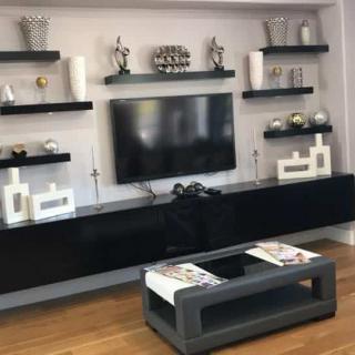 A modern living room with a sleek entertainment center and decorative shelves.