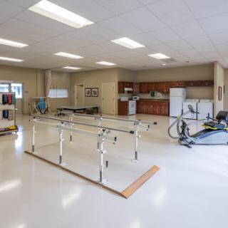 A spacious rehabilitation room equipped for physical therapy sessions.
