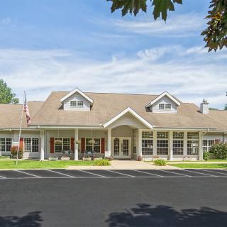 Suburban residential building with a well-maintained lawn and clear blue sky.