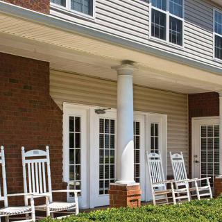 A cozy porch with rocking chairs in front of a building.