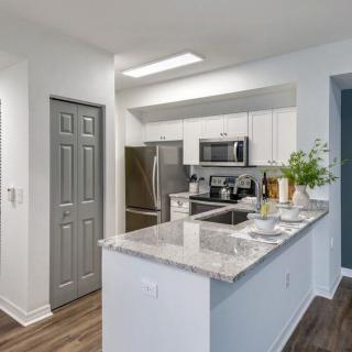 A modern kitchen with stainless steel appliances and a marble countertop.