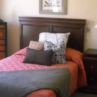 A cozy bedroom with a neatly arranged bed and pillows.