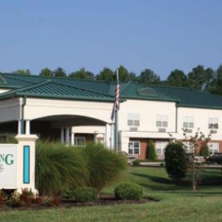 A healthcare building with a green roof and landscaped surroundings.