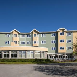 A four-story residential building with a modern design and light-colored facade.