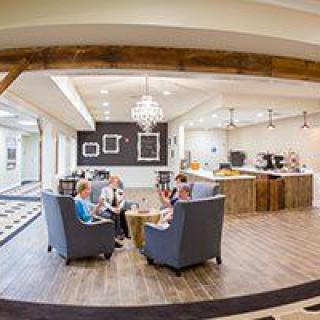 A modern lobby with a seating area and chandelier.