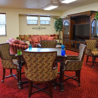 A cozy living room with a seating area, dining table, and entertainment center.