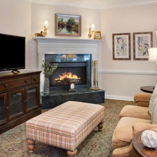 A cozy living room featuring a fireplace, television, and comfortable seating.
