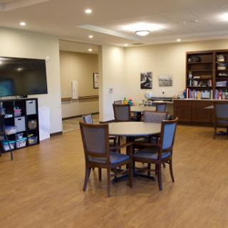 A spacious and modern common area featuring tables and chairs, perfect for gatherings or relaxation.