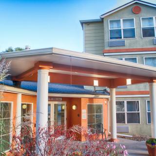 A residential building with a covered entrance and large windows.