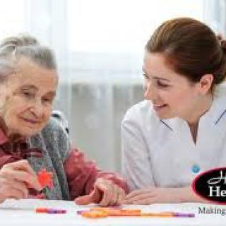 A caregiver assisting an elderly woman in a supportive environment.