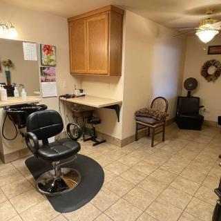 A cozy salon with a barber chair, mirror, and waiting area.