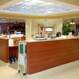 A hospital reception area with a central desk and staff working.