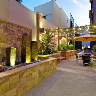 A modern outdoor patio with a fountain and string lights creates an inviting evening atmosphere.