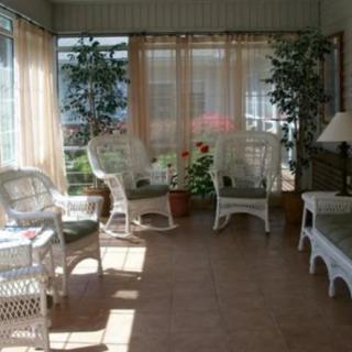 A cozy sunroom with wicker furniture and indoor plants basking in natural light.