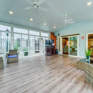 A spacious and well-lit living room with hardwood floors, modern furniture, and large windows.